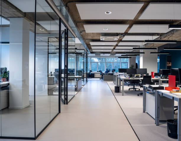 Amenagement de bureaux en open space avec un couloir central au milieu des postes de travail