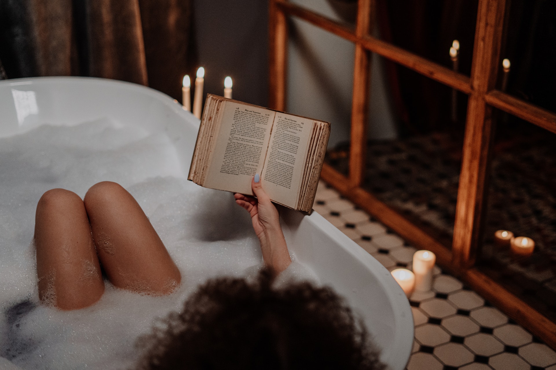 femme qui lit un livre dans sa salle de bain