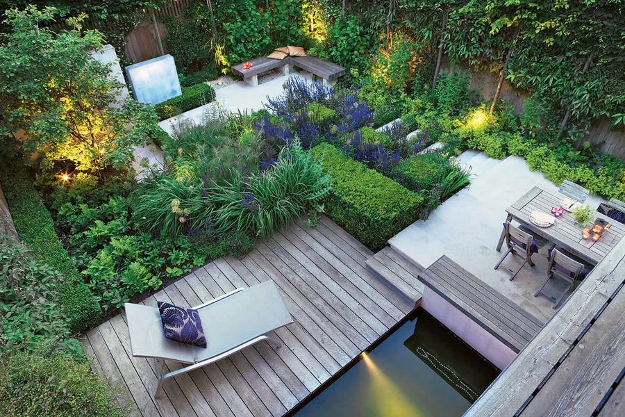 Salon de jardin avec un transat et des plantes vertes.