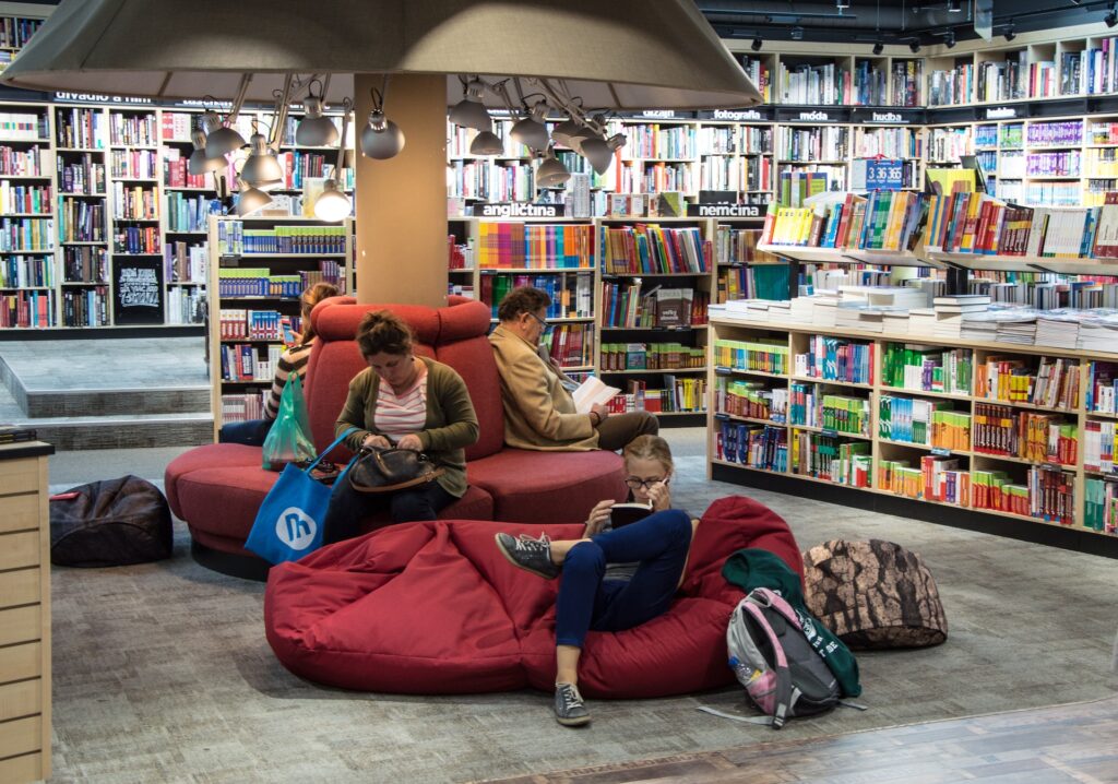 un aménagement de magasin de livres avec des canapés et des poufs