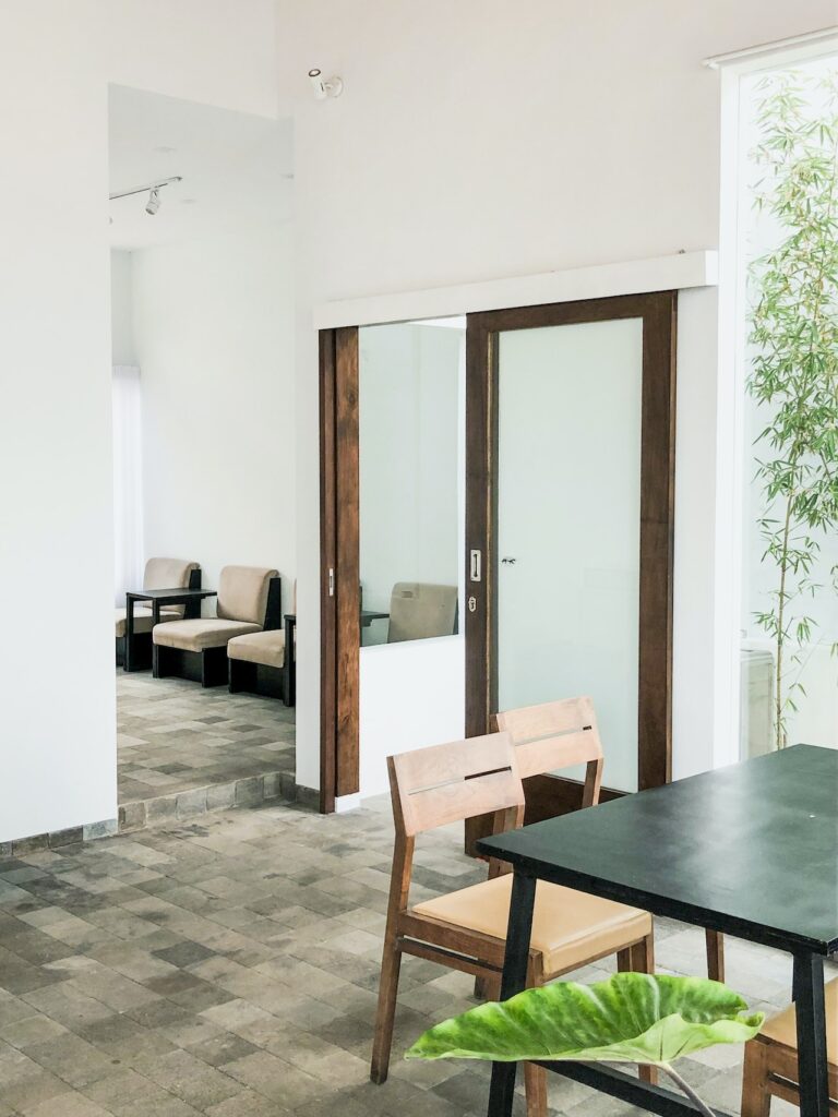 intérieur d’une maison moderne d’architecte avec sol en pierre, murs blancs et verrière