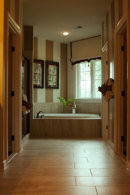 Une grande salle de bain illuminée avec ouverture sur le couloir.