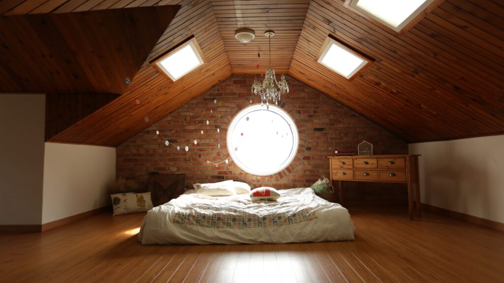 Un comble réaménagé en une chambre comportant un grand lit-double.