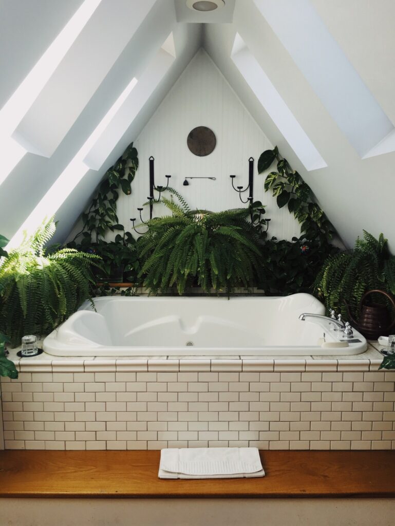 une rénovation de salle de bain avec une baignoire entourée de plantes vertes