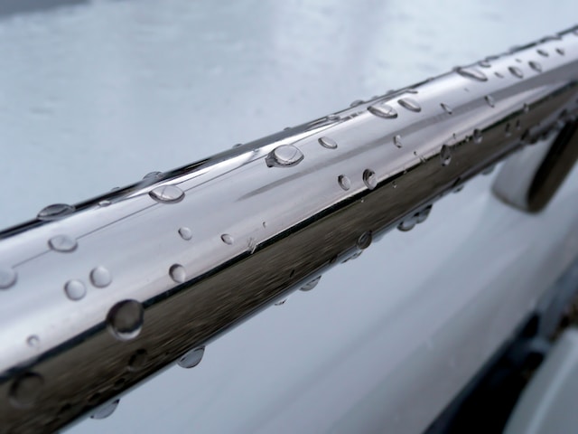 Une barre en acier inoxydable avec quelques gouttes de pluie dessus.