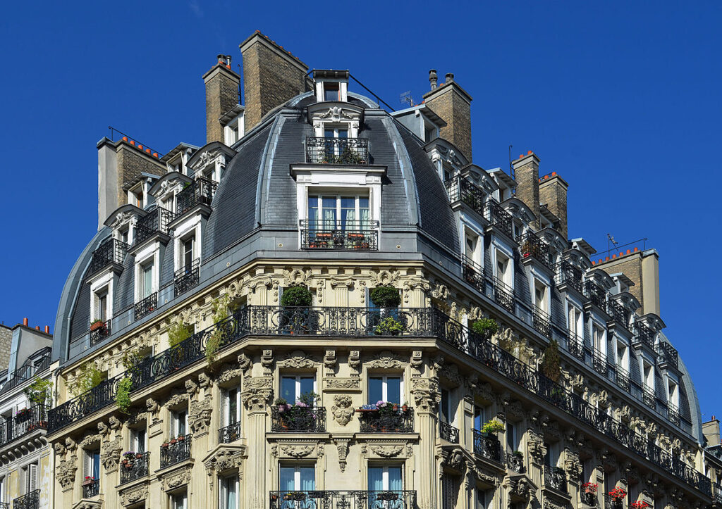 Façade d'un appartement Haussmannien en pierre de taille, avec balcon filant et sculptures