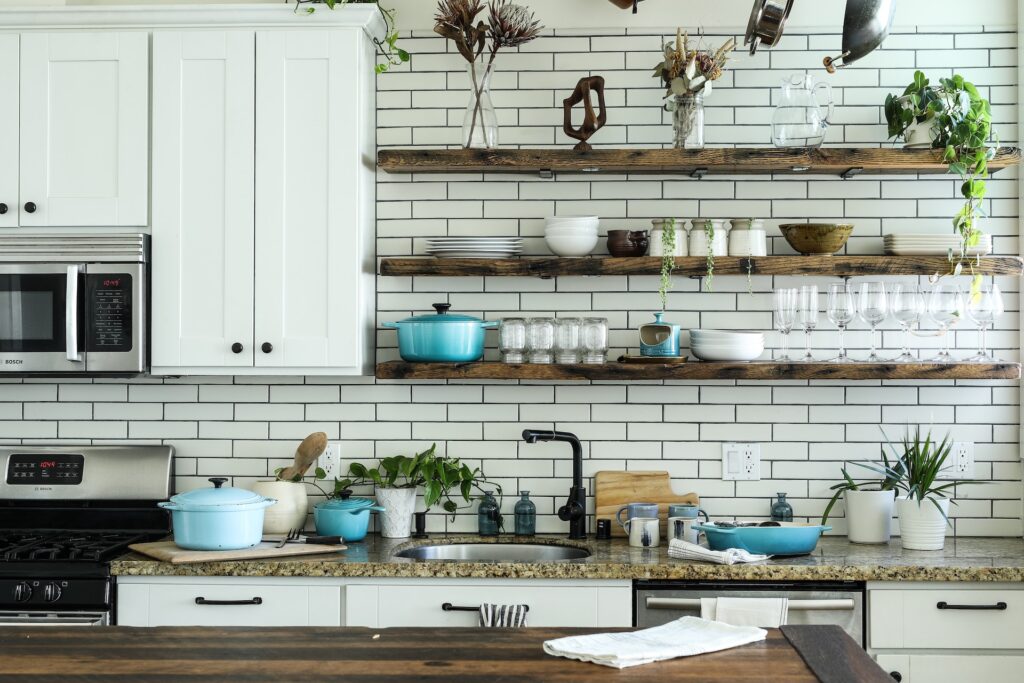 étagères dans une cuisine avec objets de déco, vaisselle et plantes disposés dessus de manière harmonieuse