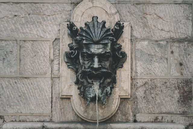 Fontaine murale, en forme de tête humaine.
