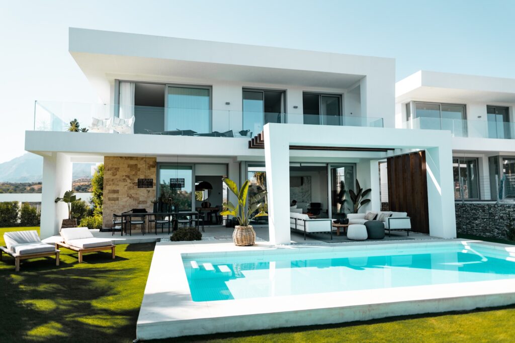 Grande villa moderne blanche et minimaliste avec de nombreux espaces verts et une piscine