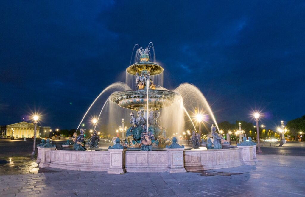 Belle et grosse fontaine centrale de nuit.