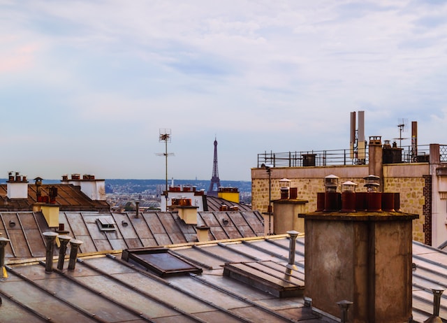 Tirage de cheminée sur les toits de Paris avec la Tour Eiffel au loin.