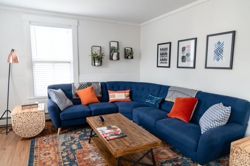 Salon avec canapé en angle accompagné d'une décoration qui appuie le confort visuel et matériel du mobilier