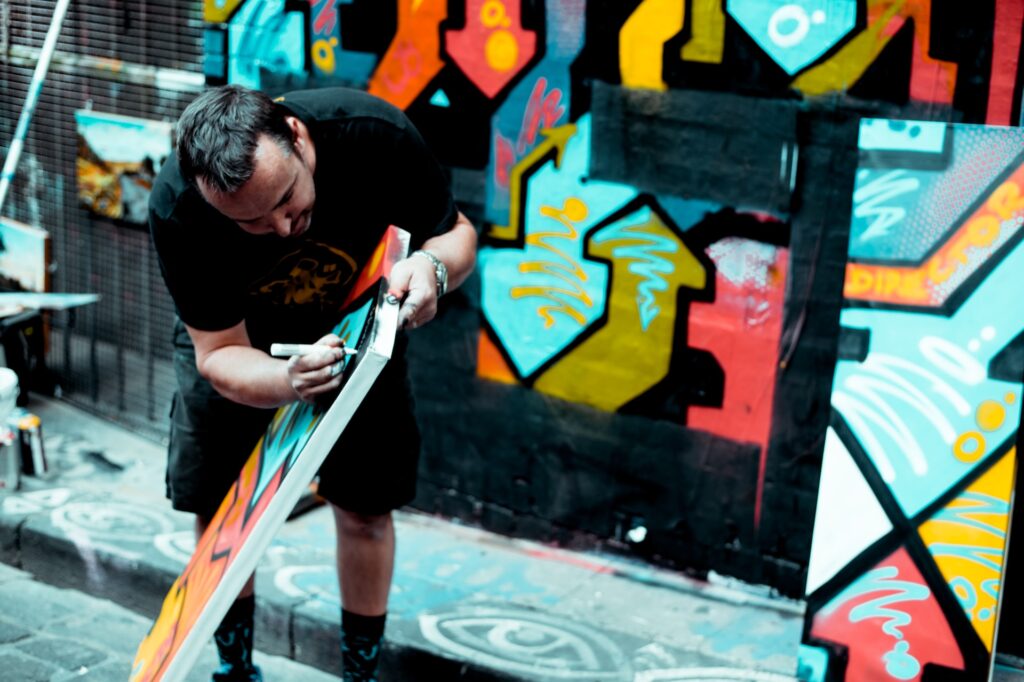 Un homme dessine ou tague un carrelage mural ou au sol pour offrir une décoration originale et moderne