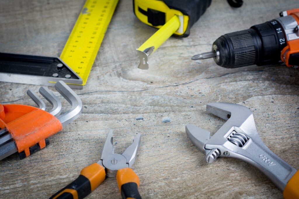 Différents outils de travaux comme une règle, un marteau, un tournevis, un mètre et différentes pinces