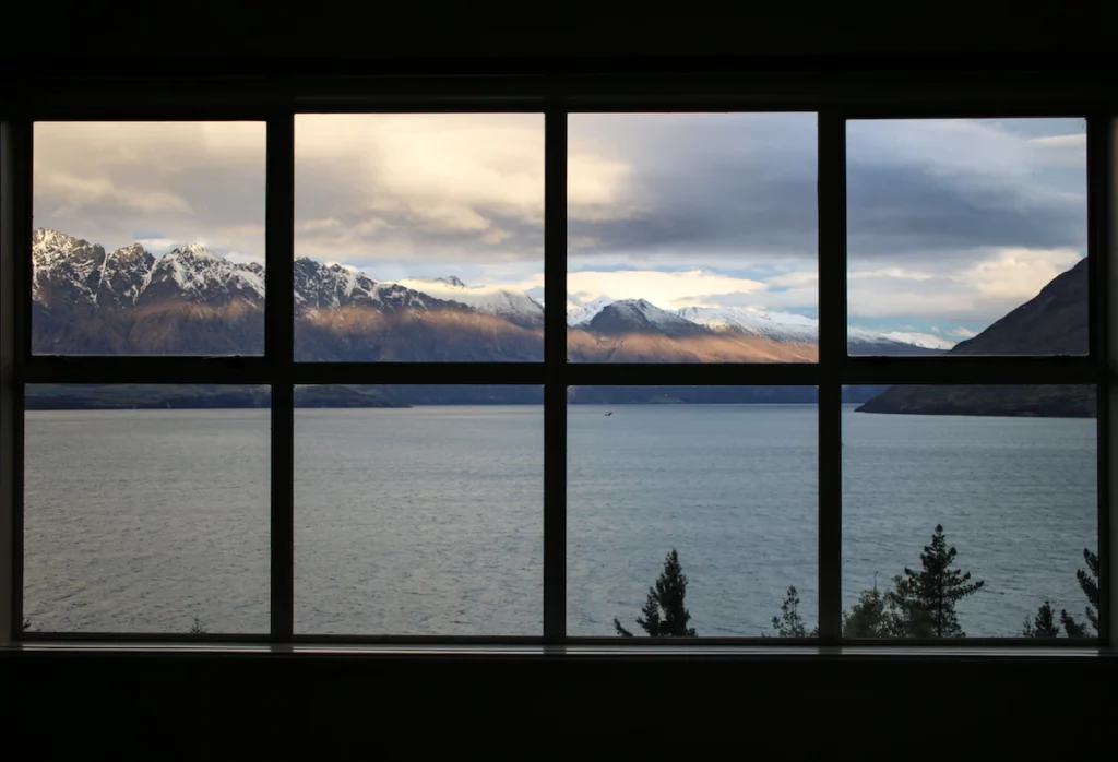 photo prise de l'intérieur vue sur un lac et des montagnes