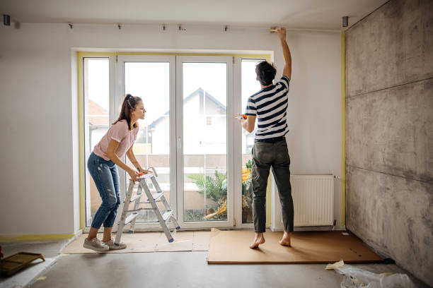 Jeune couplant realisant des travaux de renovation avec du placo au mur