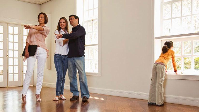 Un couple avec un enfant visite une maison des année 70 avec un agent immobilier